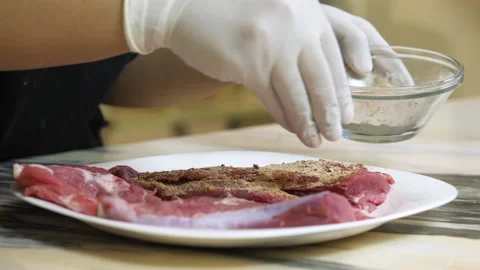 Chef spices raw beef steak in preparation for roasting Stock Footage 135477055
