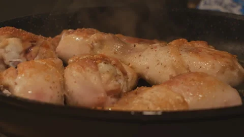 The chef spices spices on chicken or turkey drumsticks fried in a pan. Poultry Stock Footage 143667572