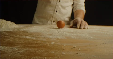 Chef spin egg on table before cracking it in flour 스톡 동영상 126299414