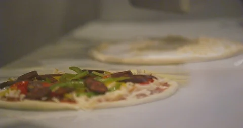 Chef spreading cheese toppings on pizza base Stock Footage 101195831