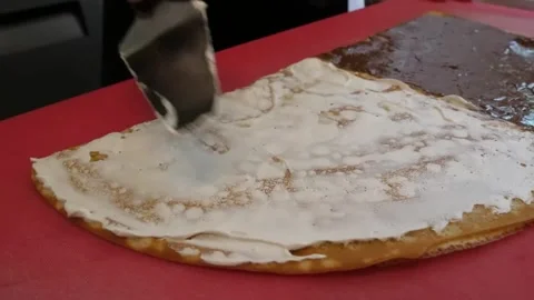 Chef Spreading Cream and Chocolate Filling on Fresh Crepe Stock Footage 345691955
