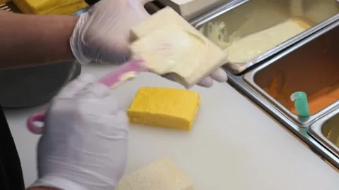 Chef Spreading Creamy Sauce on Fresh Bread Slices in Professional Kitchen Stock Footage 333600538