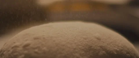Chef spreading a flour on a piece of pizza dough on a metal surface. Close up Stock Footage 146921406