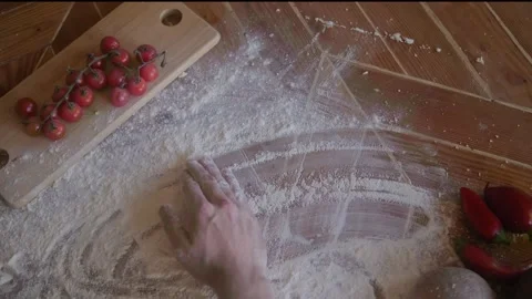 Chef is spreading flour on a wooden table to prepare pizza dough Stock Footage 290794260