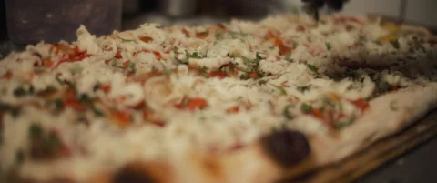 Chef spreading a fresh basil over a traditional al taglio mozzarella pizza. S Stock Footage 147518169