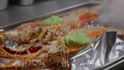 Chef spreading herb butter over split lobster 스톡 동영상 344308488