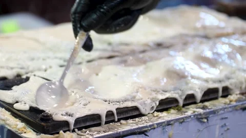 Chef spreading liquid batter with spoon in fish shaped taiyaki or bungeoppang Stock-Footage 332623415