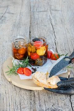 Chef spreading marinated cheese on toasted bread with cherry tomatoes and r.. Stock Photos