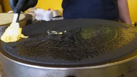Chef Spreading Melted Butter on Round Griddle to Prepare Crepes Stock Footage 345692646