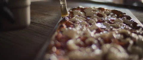 Chef spreading olive oil over a ready burrata al taglio pizza with a brush. Stock Footage 146604046