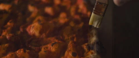 Chef spreading olive oil over freshly baked pizza dough with tomato sauce. Cl Stock Footage 146605416