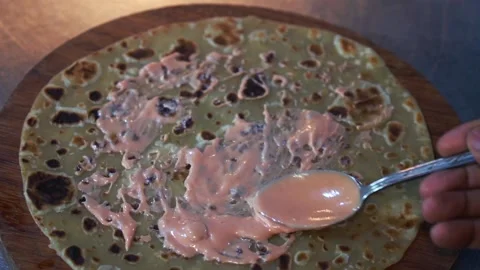 Chef spreading an orange ketchup and mayo sauce on top of tortilla Stock Footage 230080459