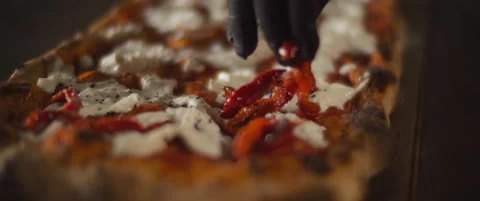 Chef spreading red peppers over a ready burrata al taglio pizza. Close up, sl Stock Footage 146604281
