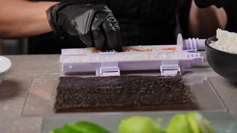 Chef spreading rice on nori sheet using sushi machine Vidéo 289540591