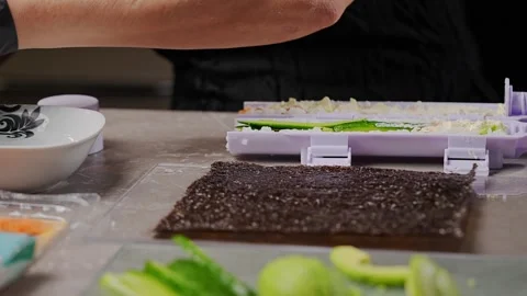 Chef spreading rice on nori sheet using sushi machine Vidéo 289540655