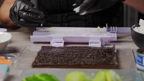 Chef spreading rice on nori sheet using sushi machine Vidéo 289540701