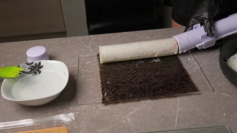 Chef spreading rice on nori sheet using sushi machine Vidéo 289613889