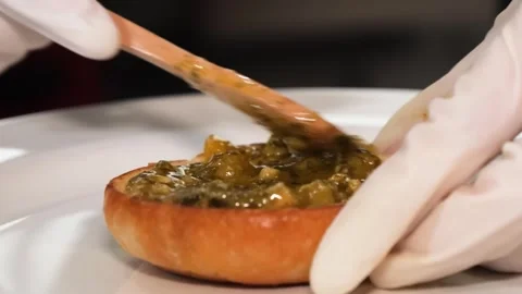 Chef Spreading Savory Green Olive Tapenade on Toasted Crusty Bread Stock Footage 331633295