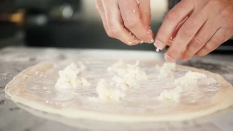 Chef spreading sour cream and cheese over pizza dough, cooking italian pizza Stock Footage 149999580