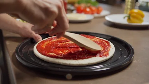 Chef spreading tomato chef on pizza dough Stock Footage 125471782