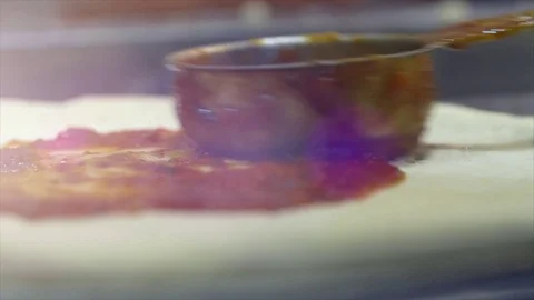 Chef spreading tomato sauce on pizza dough with a metal ladle in pizza Video stock 75652558