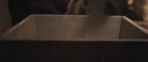 Chef spreading a white flour over a big plastic container with a dough. Close Stock Footage 146923164