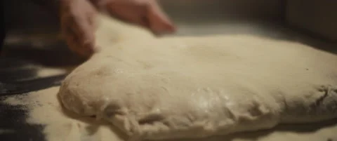Chef spreading white flour over a fresh unprepared italian pizza dough. Stock Footage 147517930