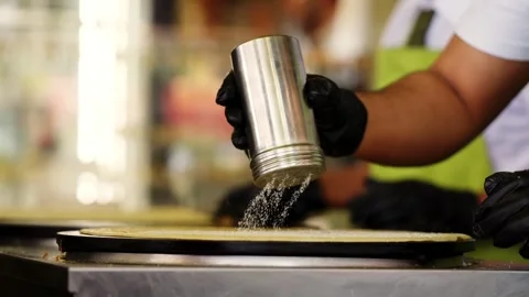 A chef spreads powder sugar over a crepe in a restaurant in Paris Stock Footage 321930153