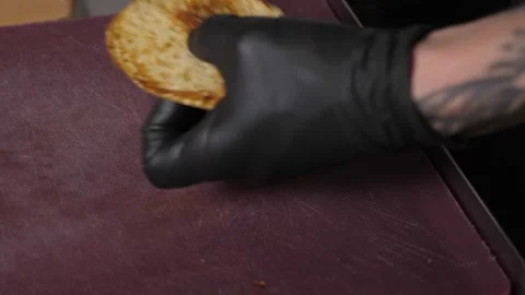The chef spreads white sauce with a spoon on half of a grilled burger bun. Stock Footage 342702196