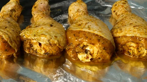 Chef sprinkle with cheese raw chicken legs in marinade. Stock Footage 131372415