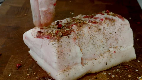 Chef sprinkle piece raw pork lard on wooden kitchen board with spices and salt. Stock Footage 234069010