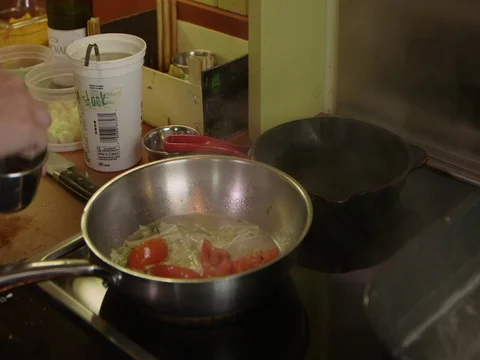 Chef sprinkle salt into veggies frying in pan Stock Footage 71555306