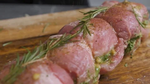 The chef sprinkle spices over a piece of meat with rosemary, prepares the food. Stock Footage 143588616