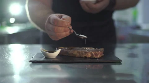 Chef is sprinkled with salt beef steak Stock Footage 63446385