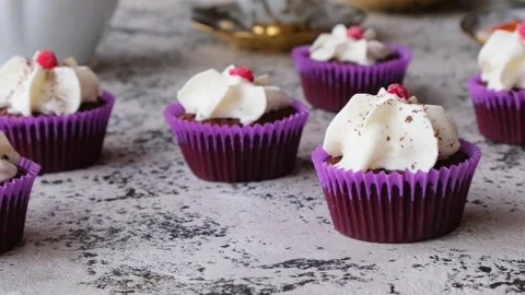 The chef sprinkles chocolate chips on dark chocolate cupcakes with cream Stock Footage 233484801