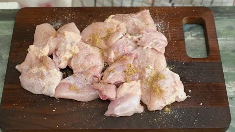 The chef sprinkles cumin on the chicken pieces. Stock Footage 247895372