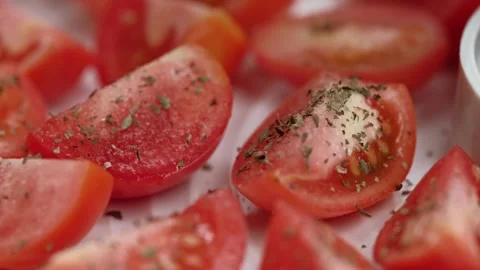 Chef sprinkles dried basil on slices of red tomatoes in vegetable dryer. closeup Stock Footage 253650802