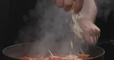 Chef sprinkles grated cheese on tomato pasta. Cooking traditional Italian pasta Stock Footage 258390612