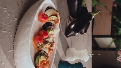 Chef sprinkles grilled vegetables eggplant zucchini tomatoes mozzarella with Stock Footage 269785973