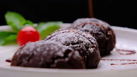 Chef sprinkles icing on homemade cocoa balls decorated with dark chocolate glaze Видео 177435549