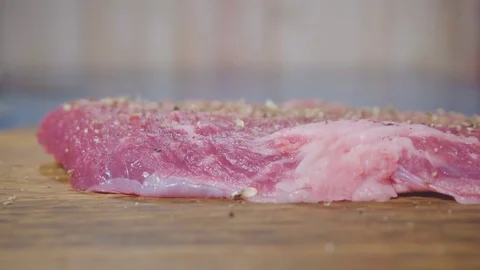 Chef sprinkles meat with spices Stock Footage 73816340
