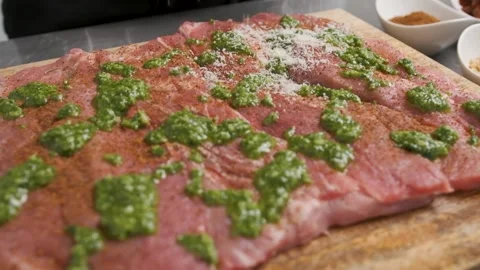 Chef sprinkles Parmesan cheese over a piece of fresh meat for dinner. Stock Footage 143268461