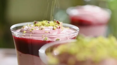 The chef sprinkles the raspberry cheesecake with pistachios. Stock Footage 200810744