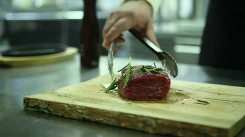 Chef sprinkles spice steak Stock Footage 61851633