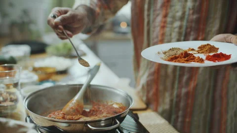 Chef Sprinkling Aromatic Spices Into Simmering Tomato Sauce in Pan Stock Footage 303014876