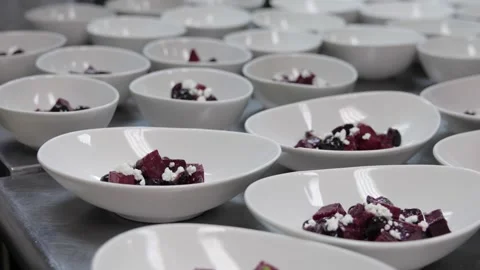 Chef sprinkling goat cheese over a beet salad for a catered dinner Stock Footage 317602324