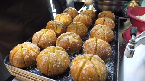 Chef Sprinkling Parmesan Cheese on Freshly Baked Korean Cream Cheese Garlic Brea Video stock 343587420