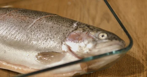 Chef squeeze orang and lime onto the whole raw salmon fish Stock Footage 99918342