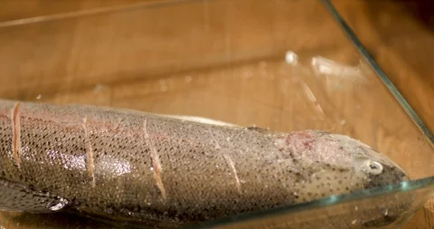 Chef squeeze orang and lime onto the whole raw salmon fish Stock Footage 99919136