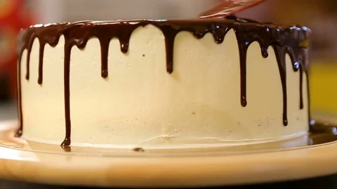 Chef squeezes cream. Chocolate icing decoration on cake Stock Footage 82453394